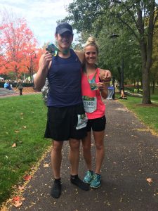 Man and woman post run holding medals