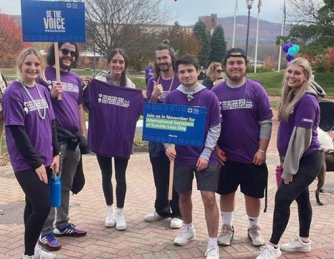 A group of Campus Recreation student employees stand together in matching purple shirts at the 2022 Out of the Darkness walk.