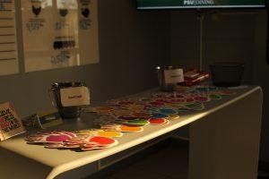 This image shows a table with meal swipe cards on top and donation bins.