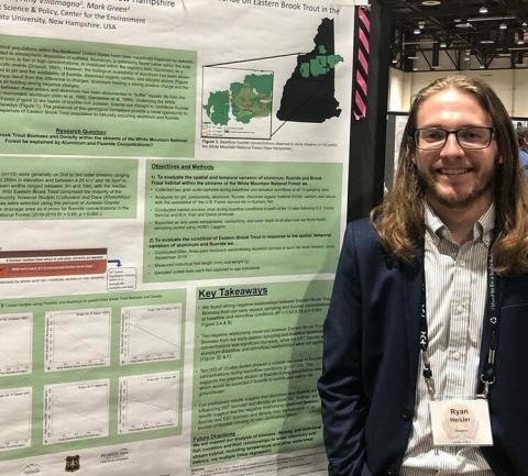 PSU Graduate Ryan Heisler stands next to his research poster.