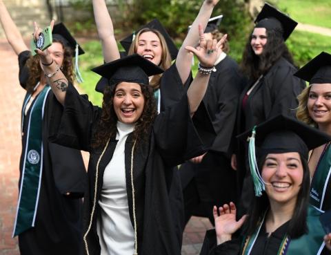 Group of students in cap and gown celebrate commencement