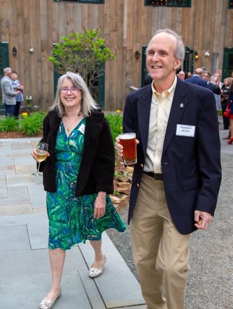 A woman, Mary Anne Hyde Saul, and a man, Bert Saul, smiling and standing outside at a celebration