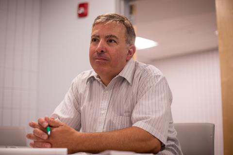 Photo of a man smiling and sitting at a desk