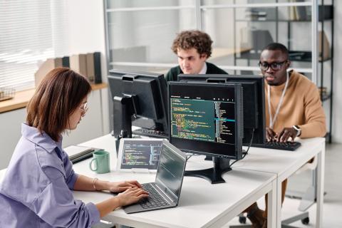 Three persons at cybersecurity computers